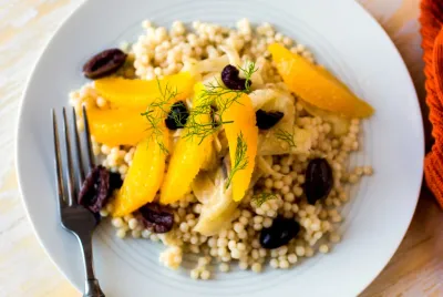 Salade de fenouil et d'orange avec des olives noires sur un lit de couscous